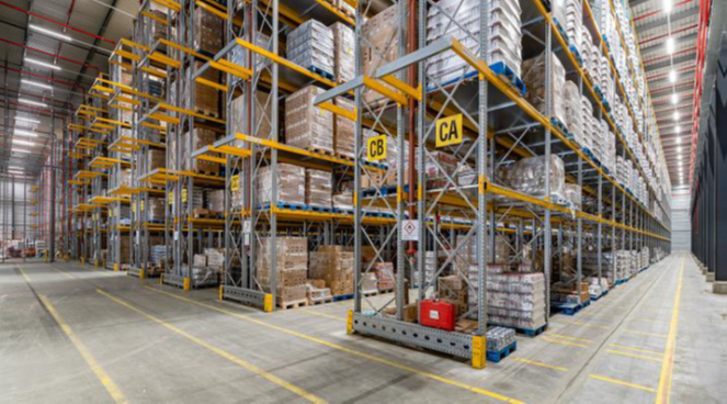 Racks in warehouse with labels on aisles and yellow lines on floor
