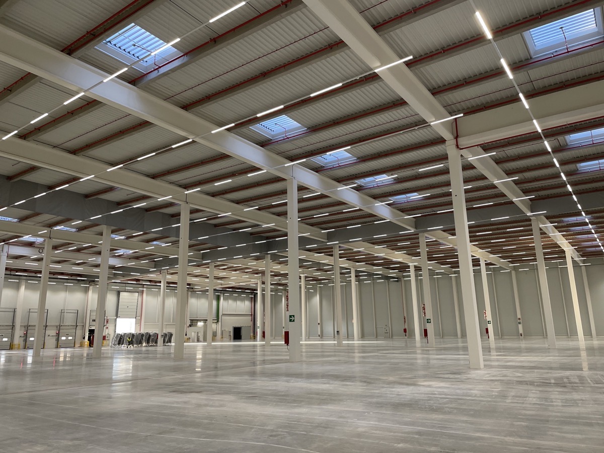 Empty warehouse showing poles in the center and size of open floor