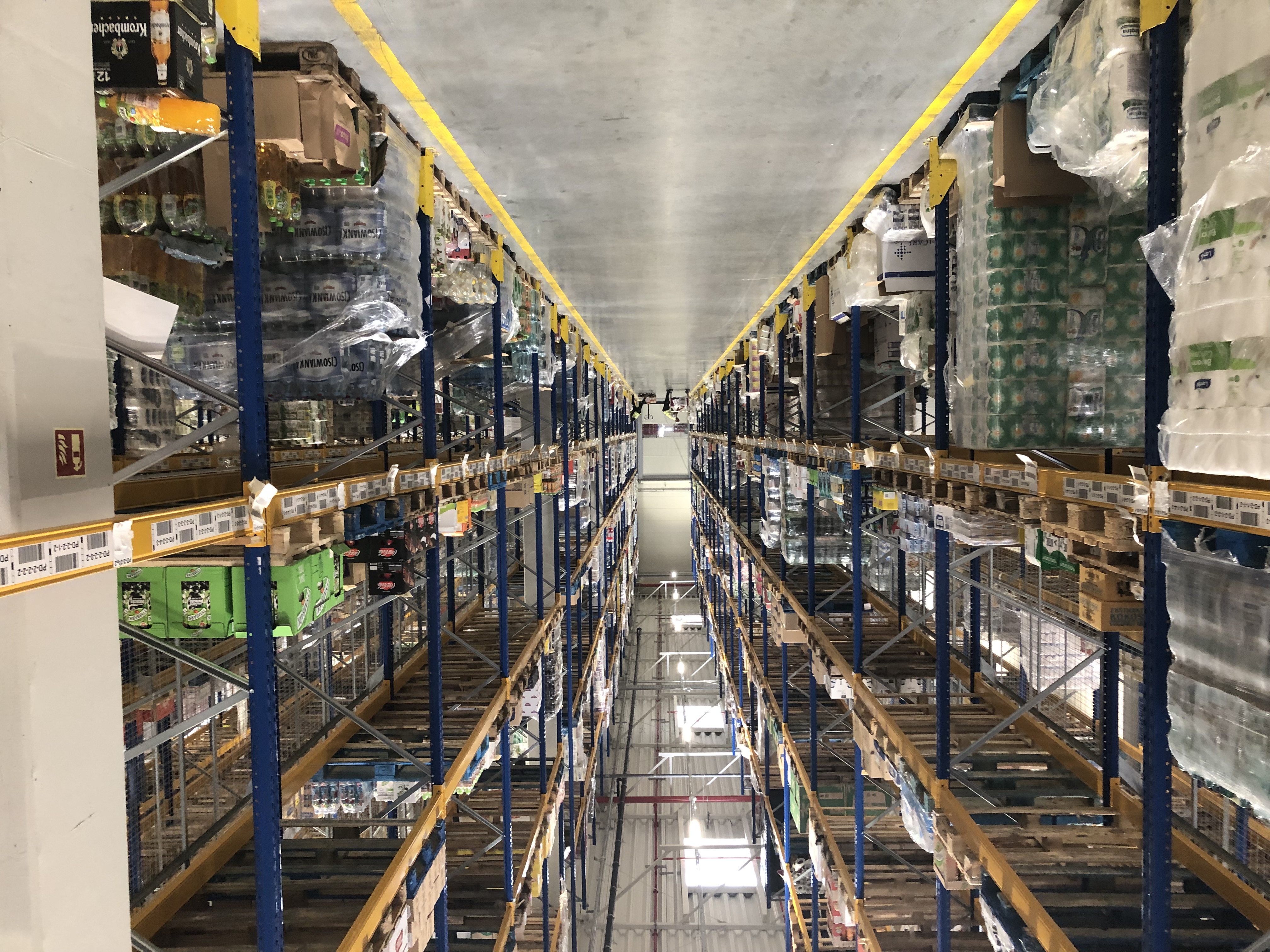 view down aisle in warehouse with materials stacked