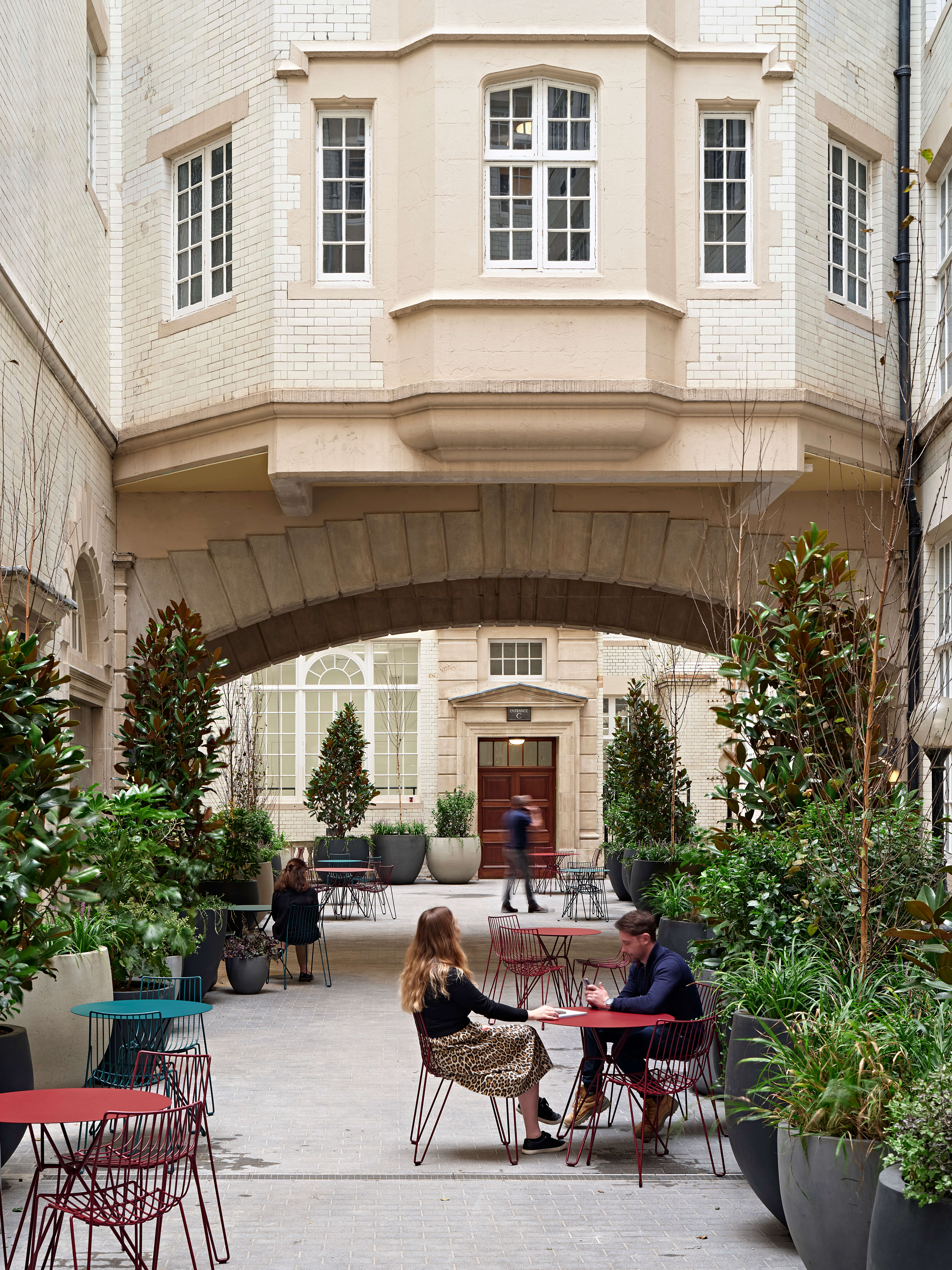 outdoor space with people sitting at tables near and archway
