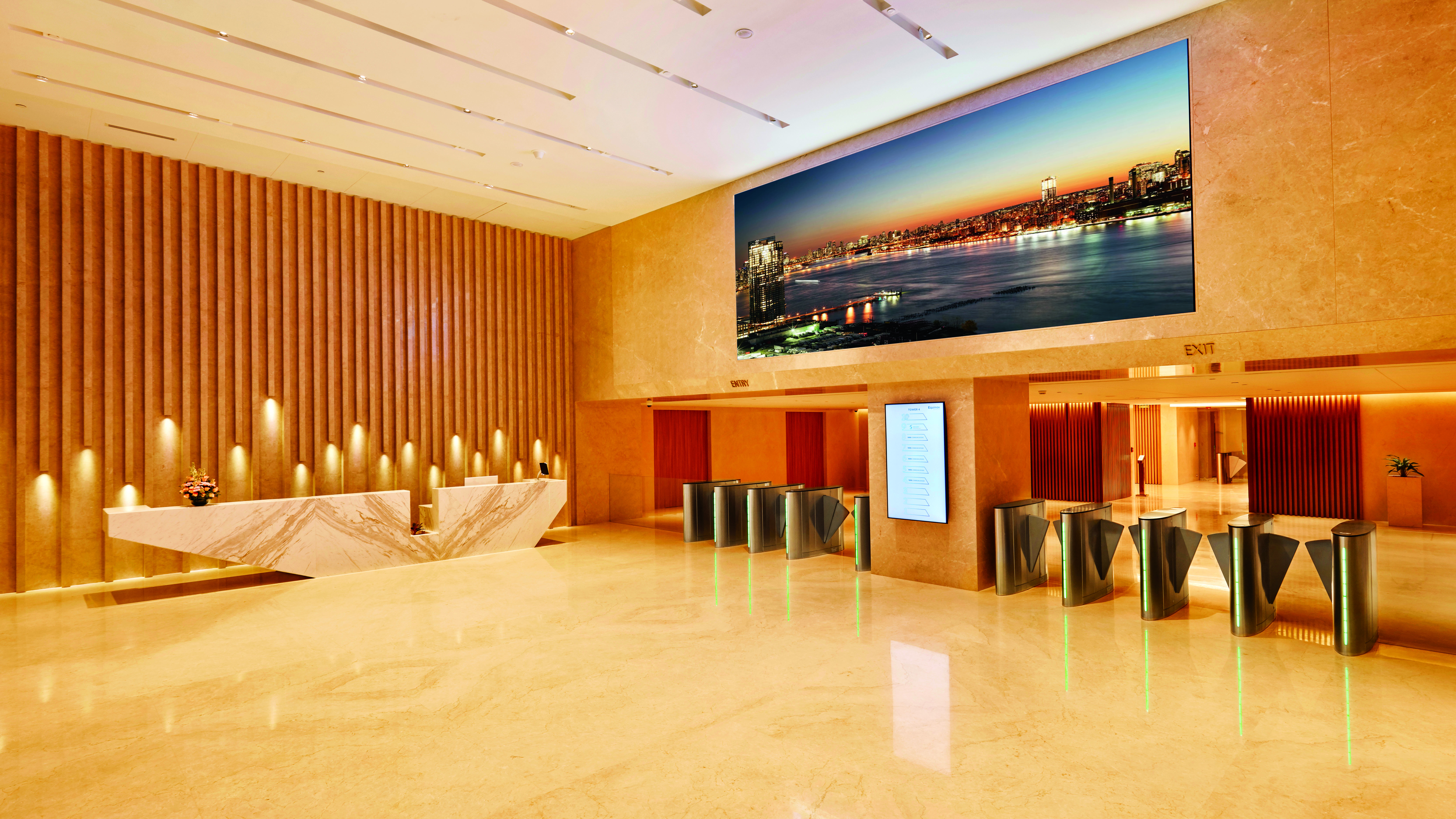 Equinox lobby in neutral colors with large white desk, secured entry