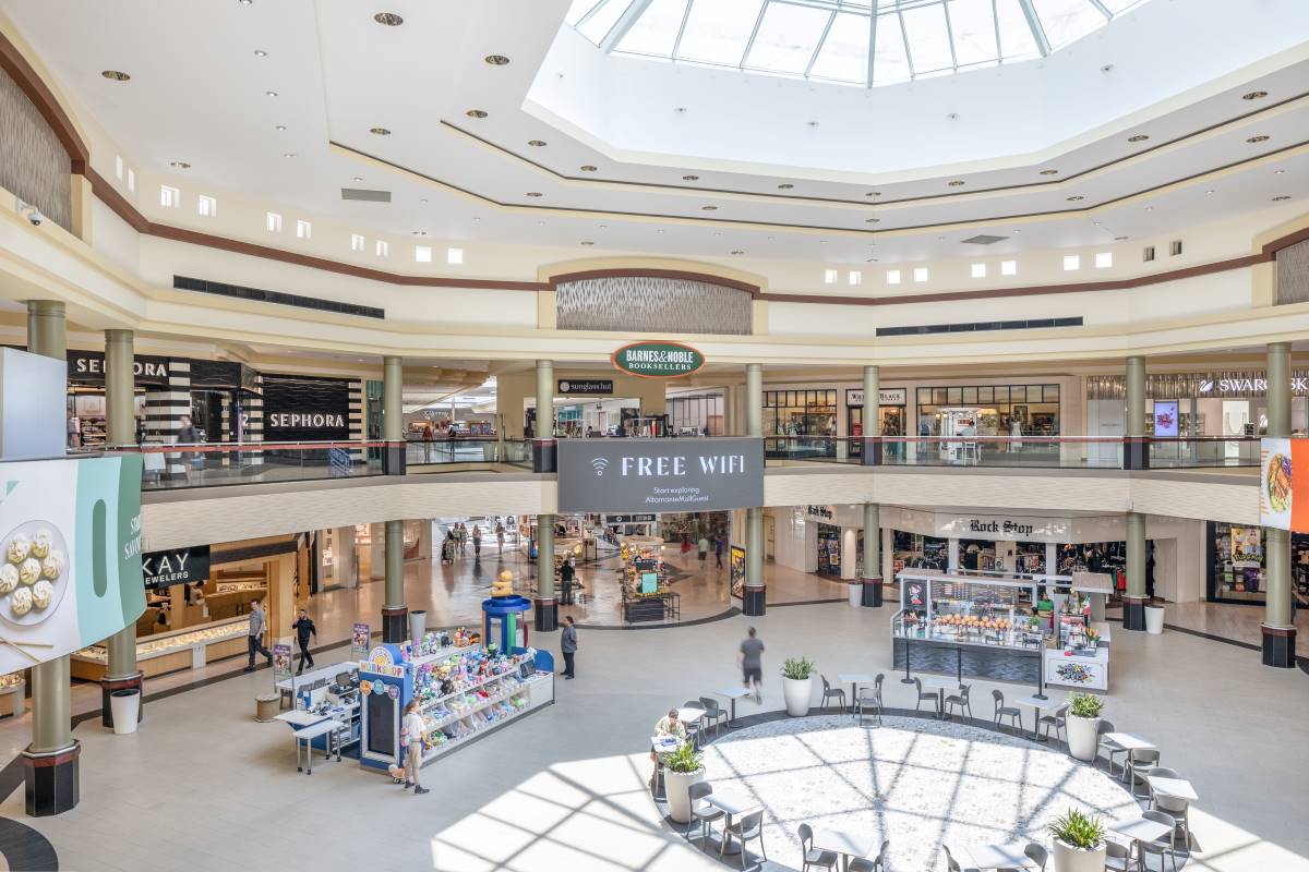 Interior view of 2 story mall with several store fronts and kiosk vendors