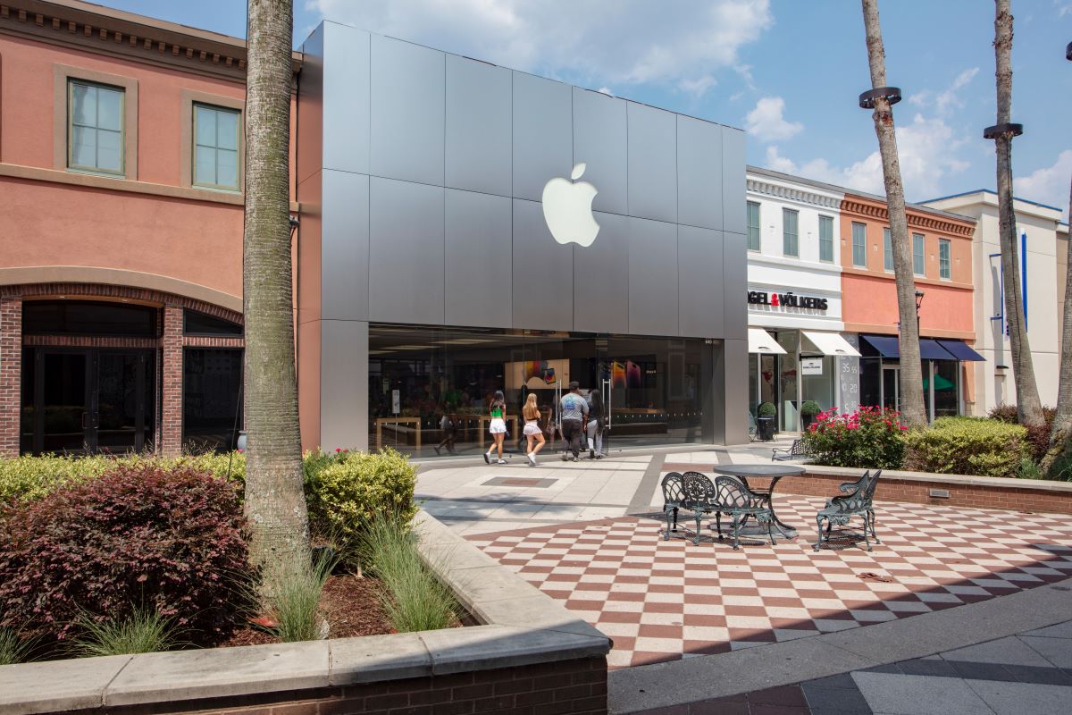 Outside storefront for Apple, shows outdoor table and chairs and landscaping