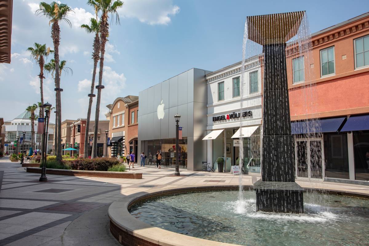 Outside at the center showing several storefronts and a feature water fountain