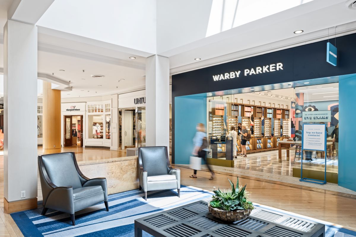 interior of shopping center showing storefronts of Warby Parker, Untuckit and Vinyard Vines
