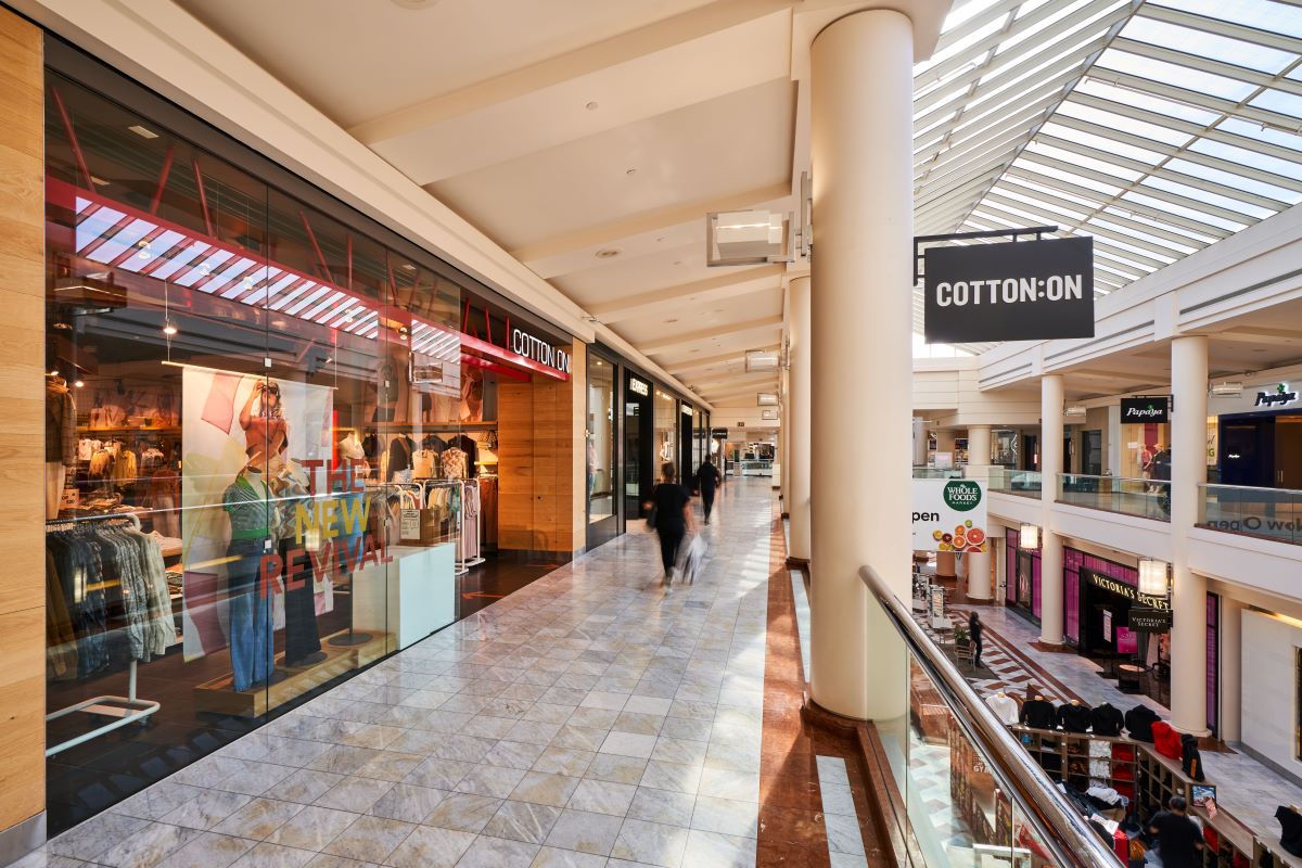Interior of the shopping center with several storefronts visible including Cotton On and Victoria's Secret