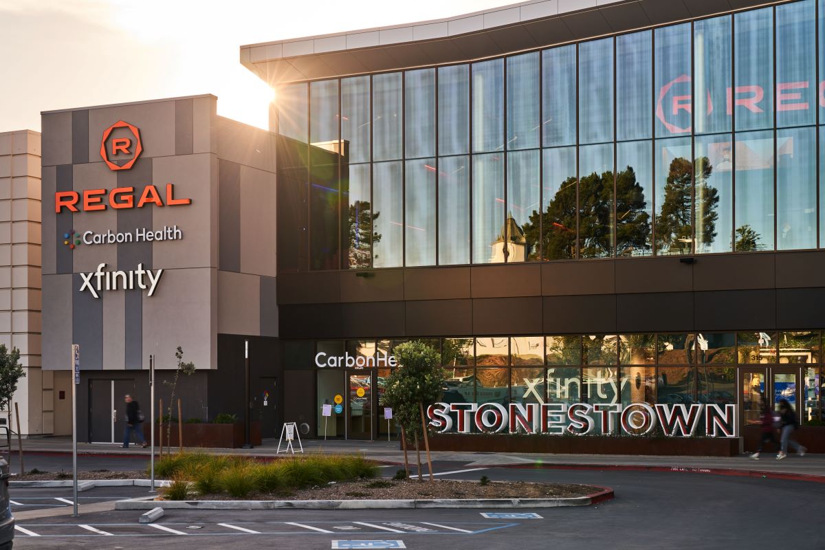 Exterior photo of Stonestown Galleria with some retailer logos including Xfinity, Carbon Health and Regal
