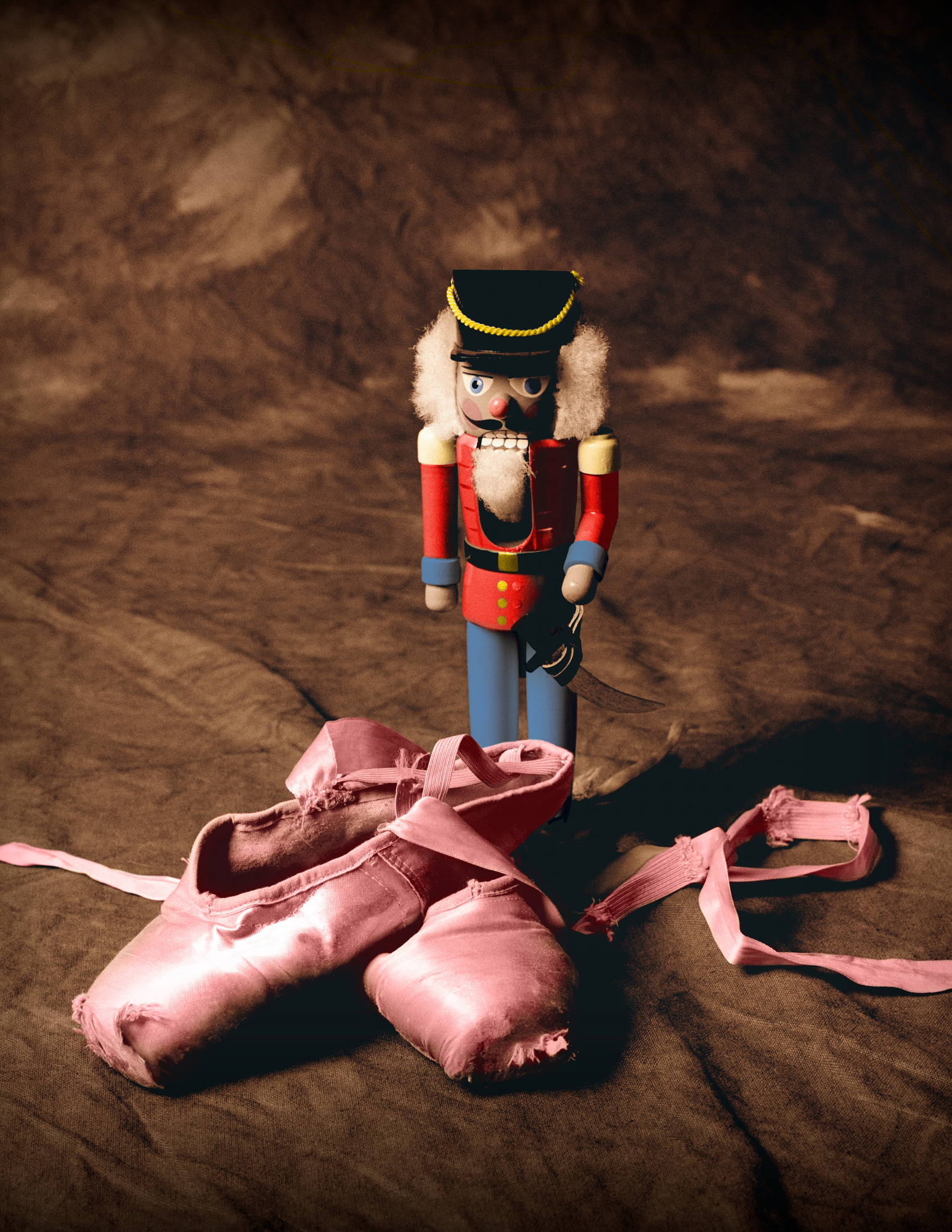 Nutcracker next to a pair of ballet slippers