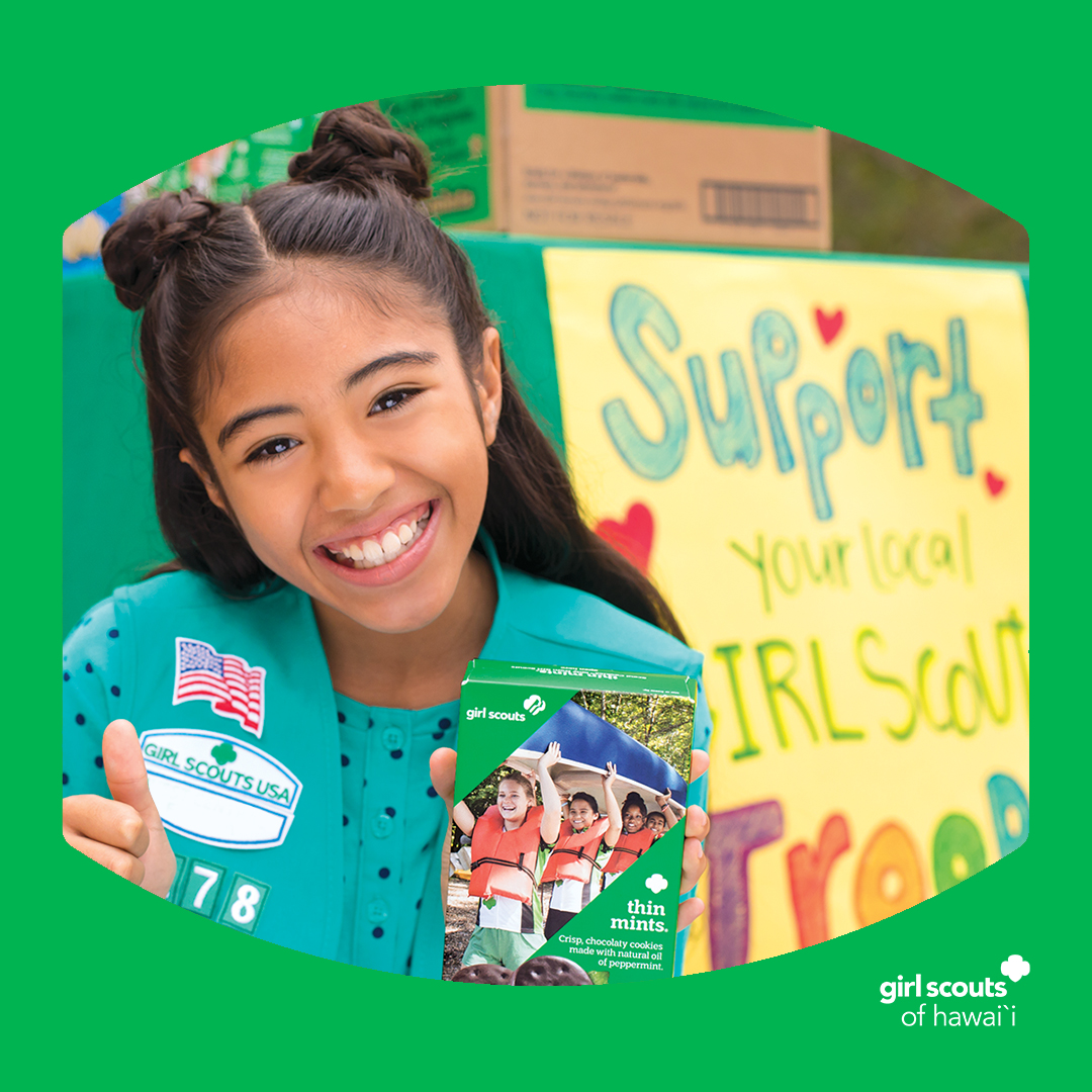 girl scout holding a box of cookies